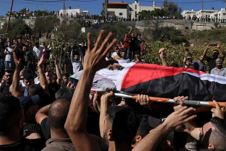 Palestinos carregam corpo de Mahmud al-Atrash, morto por soldados israelenses em conflito na Cisjordânia