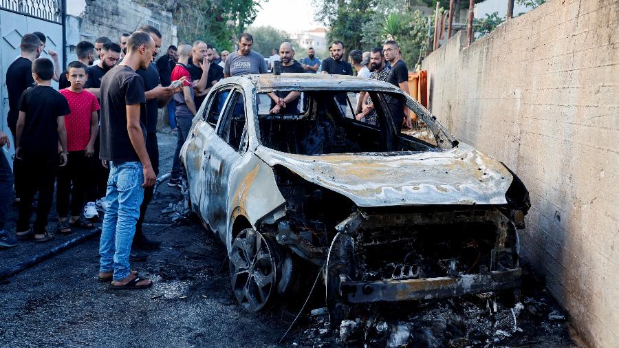 30.ago.24 - Palestinos avaliam os danos no local de um ataque israelense a um carro perto de Jenin, na Cisjordânia ocupada por Israel - Raneen Sawafta/REUTERS