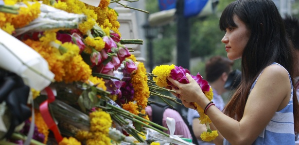 Mulher deposita flores no santuário ao ar livre de Erawan, local do atentado que deixou 20 mortos na última segunda-feira - Chaiwat Subprasom/Reuters