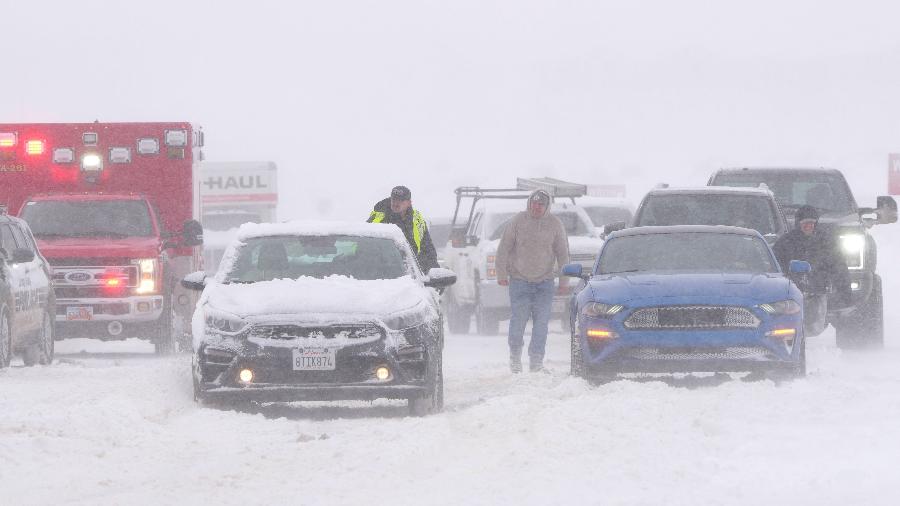 Policiais e equipes de emergência tentam libertar veículos da neve em Mountain View Parkway em Lehi, no estado de Utah, durante nevasca - 22.fev.2023 - George Frey/AFP