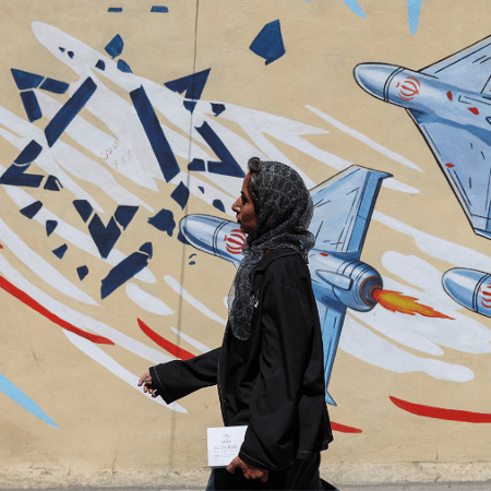 15.jun.26 - Mulher passa por mural anti-israelense em Teerã, Irã