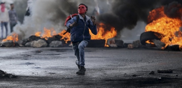 Palestino usa estilingue para arremessar pedras contra tropas israelenses na Cisjordânia - Mohamad Torokman/Reuters