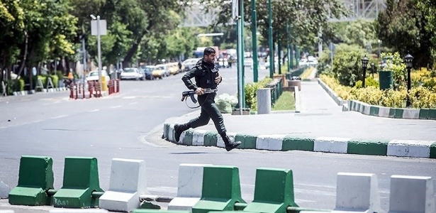 Integrante das forças de segurança do Irã corre durante ataque ao Parlamento, em Teerã - Tasnim via Reuters