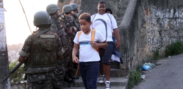Crianças cruzam com soldados em patrulha na favela da Rocinha, no RJ (27.out.2017) - José Lucena/Futura Press/Estadão Conteúdo
