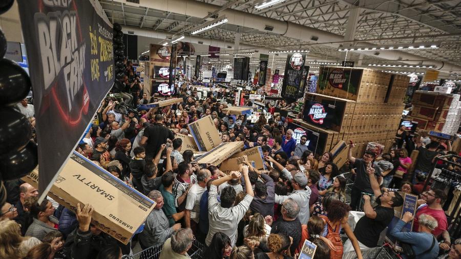 Consumidores carregam caixas de TVs durante Black Friday do ano passado em uma loja da rede Extra, em São Paulo - Suamy Beydoun/Agif