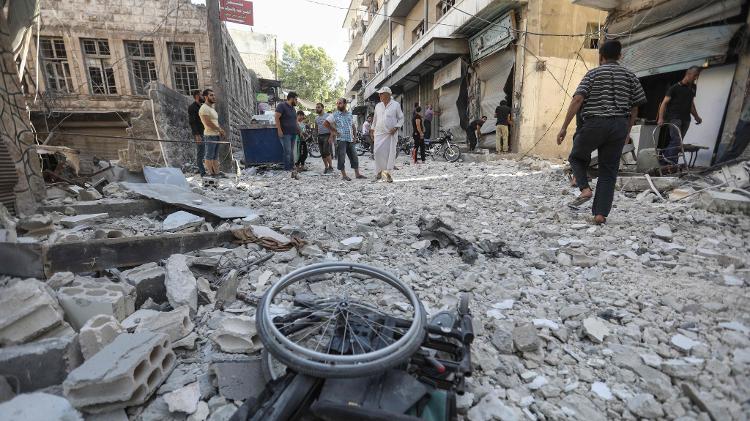 Cadeira de rodas em meio aos escombros dos edifícios destruídos em Ariha - Omar Haj Kadour/AFP