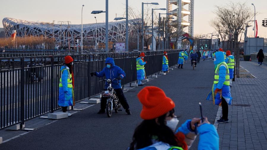 Voluntários fazem um isolamento para a bolha em torno do Estádio Nacional, em Pequim - Thomas Peter/Reuters