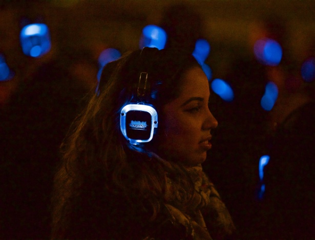 22.mai.2015 - Mulher usa fone de ouvido durante festa silenciosa em South Street Seaport, Nova York - Benjamin Norman/The New York Times