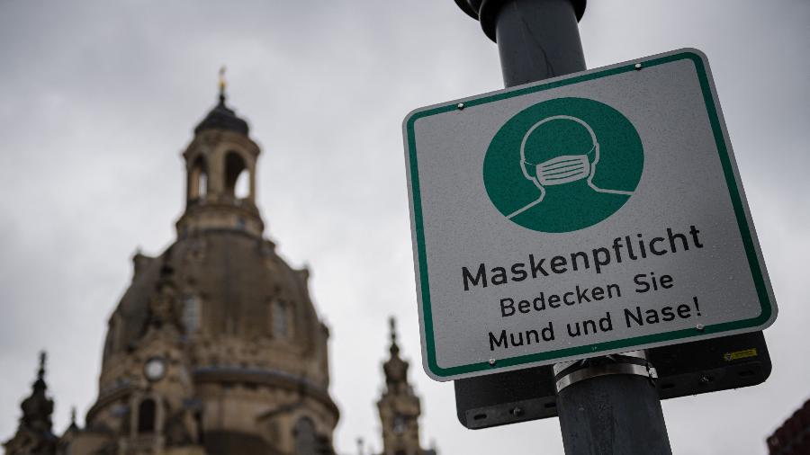 12.abr.2021 - Placa onde se lê "máscara obrigatória, cubra sua boca e nariz" é pendurada em um poste em frente à Frauenkirche (Igreja de Nossa Senhora) em Dresden, Alemanha - Jens Schlueter/AFP