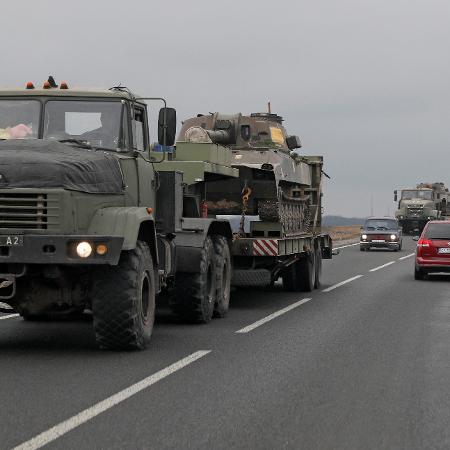 24.fev.2022 - Caminhões das Forças Armadas ucranianas transportam veículos blindados na região de Kiev, Ucrânia