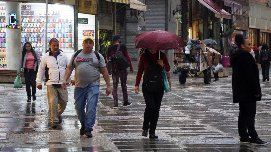 Pessoas se protegem da chuva e do frio na região central de São Paulo