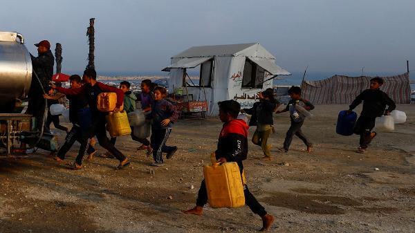 Palestinos deslocados correm para encher recipientes com água na Cidade de Gaza
