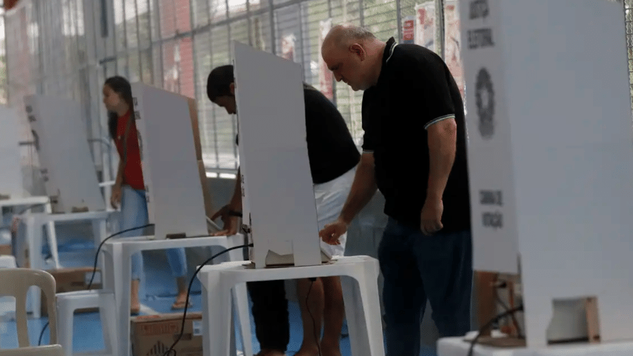 Eleitores registram suas escolhas na urna