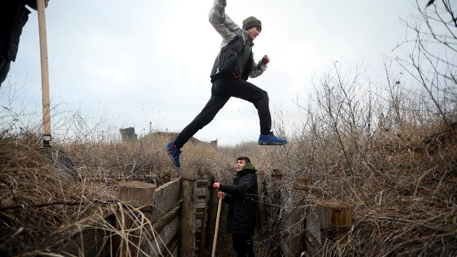 11.fev.2022 - Adolescentes ucranianos cavam para soldados que servem na frente oriental de seu país e enfrentam separatistas apoiados pela Rússia, perto da vila de Chervone, no leste da Ucrânia - Aleksey Filippov/AFP