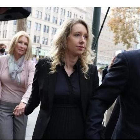 Holmes (no centro) junto com o marido e a mãe dela enquanto entravam no tribunal - Getty Images