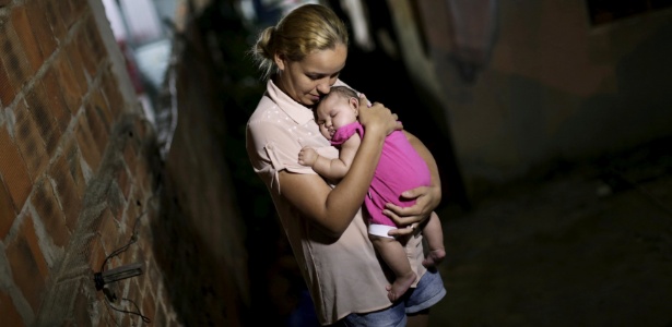 Mãe segura a filha no colo; a menina nasceu com microcefalia - Ueslei Marcelino/Reuters
