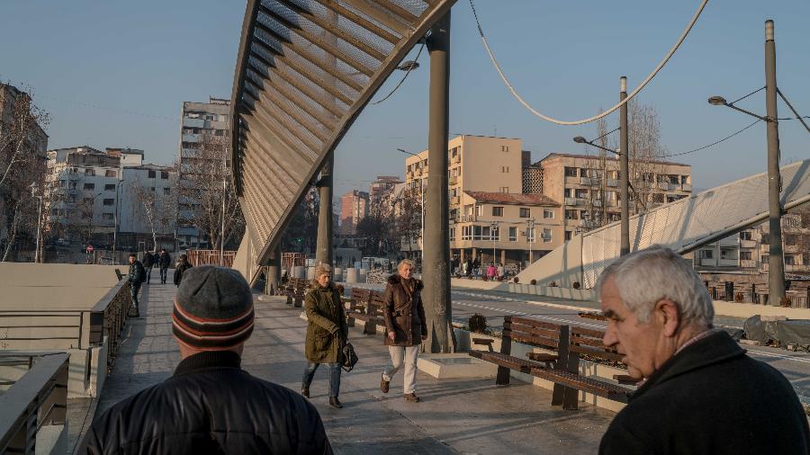 25.jan.2018 - Pessoas atravessam a ponte principal do rio Ibar, que divide as comunidades albanesas e sérvias em Mitrovica, Kosovo - Andrew Testa/The New York Times