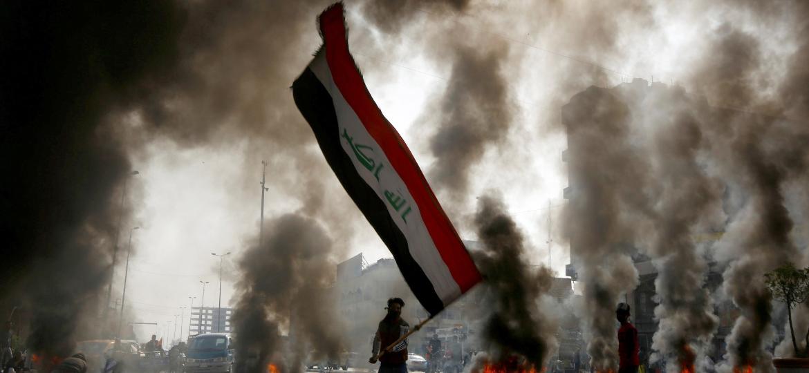 Manifestantes com a bandeira do Iraque, em Najaf, durante dia de protestos no país - Alaa al-Marjani/Reuters