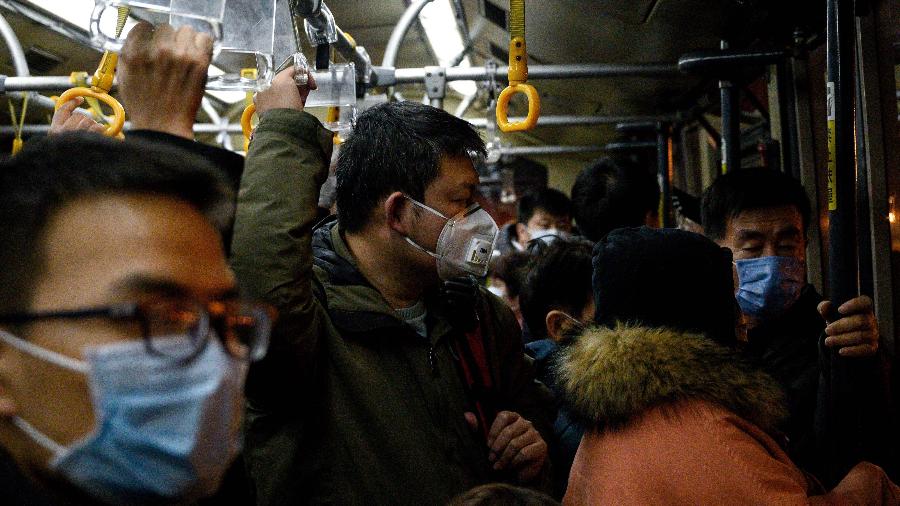 Passageiros utilizam máscaras no aeroporto Shanghai Pudong, em Shanghai, como forma de proteção ao surto de coronavírus - NOEL CELIS/AFP