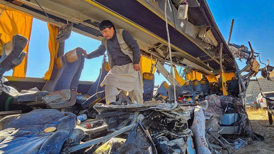 Homens inspecionam danos causados a ônibus após acidente com 52 mortos em Kabul-Kandahar