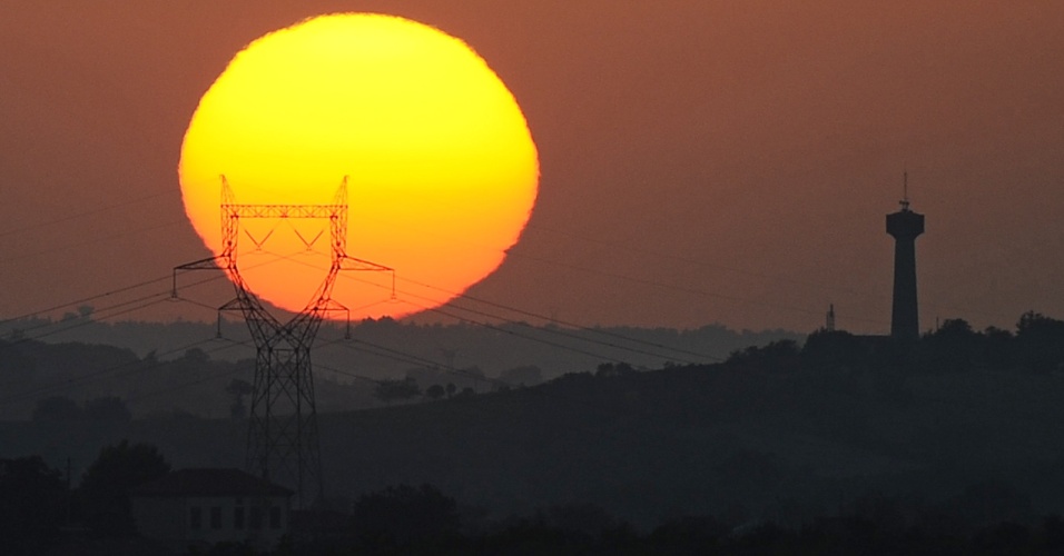 31.ago.2015 - Sol se põe atrás de uma torre elétrica perto de Saint-Félix-Lauragais, na França