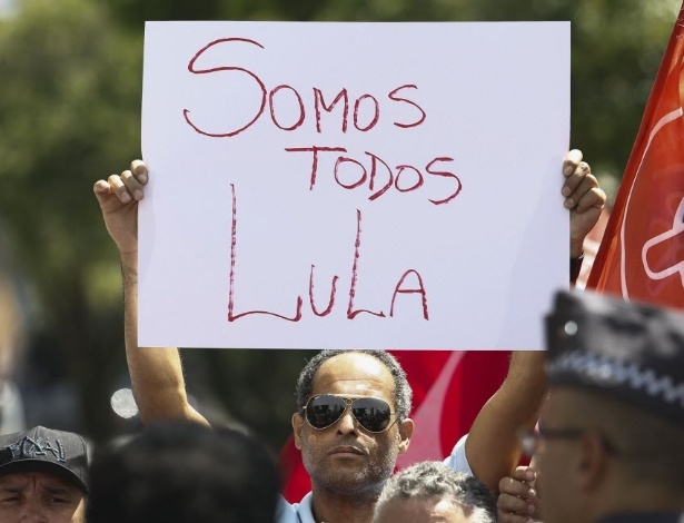 Apoiador segura cartaz onde se lê "Somos todos Lula" em frente à casa do ex-presidente Luiz Inácio Lula da Silva, em São Bernardo do Campo, em São Paulo - Miguel Schincariol/AFP