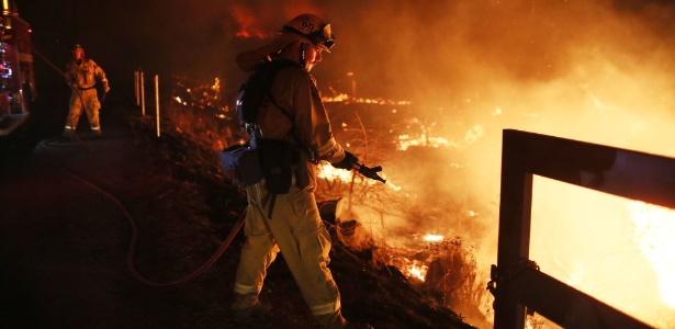  Homem do corpo de bombeiros trabalha no combate a chamas provocadas por ondas de calor - Sandy Huffaker/AFP Photo