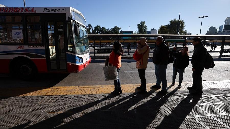 Pessoas aguardam ônibus em dia de greve geral contra presidente Javier Milei em Buenos Aires