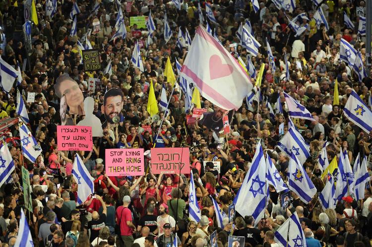 7.set.2024 - Manifestantes erguem cartazes e bandeiras durante um protesto em Tel Aviv, em Israel