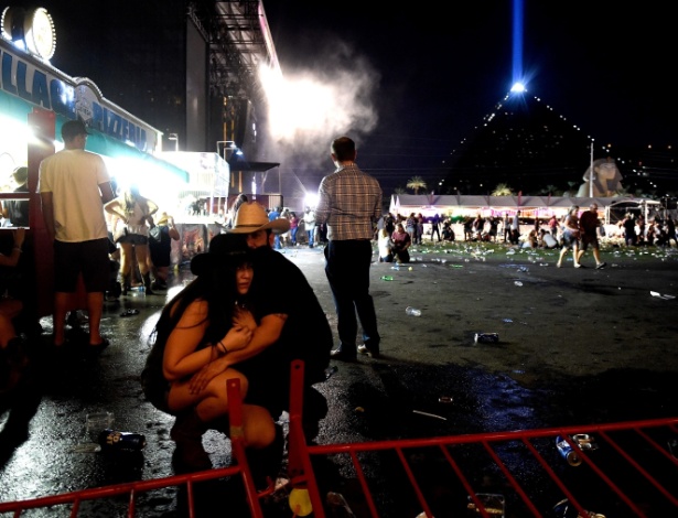 1º.out.2017 - Casal se agacha para se proteger durante ataque em festival em Las Vegas - David Becker/Getty Images/AFP