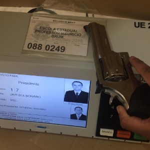 Imagem que circula nas redes sociais mostra um eleitor segurando uma arma sobre uma urna eletrônica