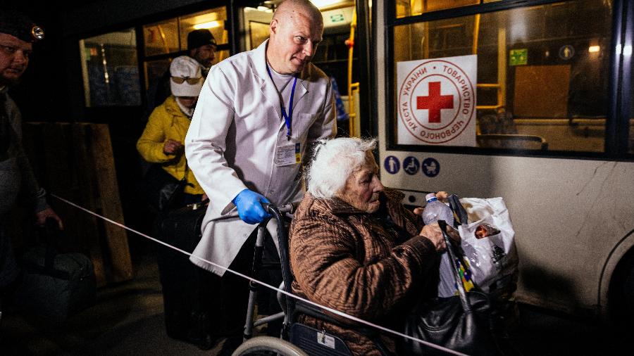 08.mai.22 - Uma mulher idosa que foi evacuada de Mariupol é empurrada em uma cadeira de rodas em uma área de registro e processamento de deslocados internos em Zaporizhzhia - DIMITAR DILKOFF/AFP