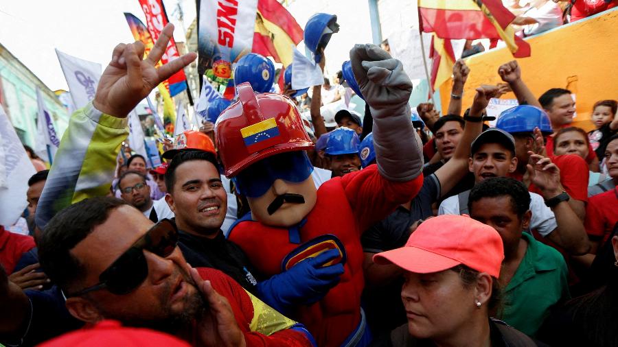 Um homem vestido de Super Bigode, personagem inspirado no presidente da Venezuela, Nicolás Maduro, gesticula durante um comício do Partido Socialista Unido da Venezuela (PSUV) em apoio a Maduro, em Caracas, Venezuela, 20 de junho de 2024