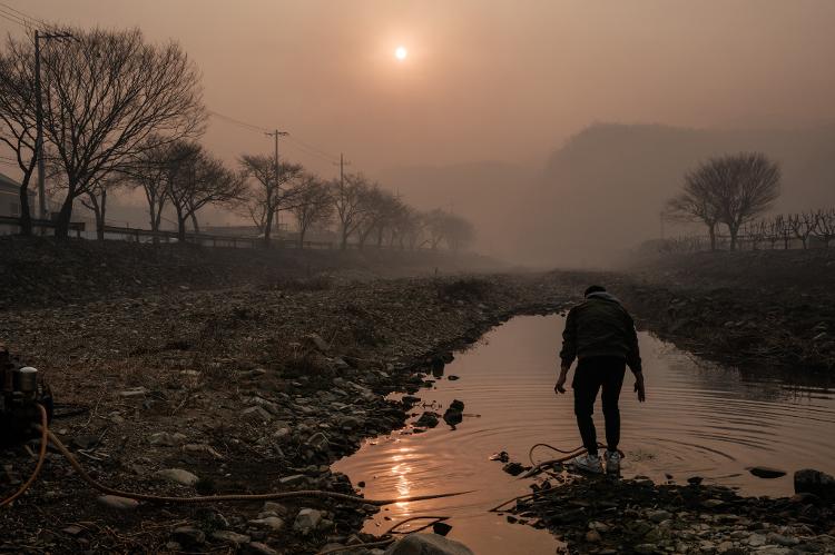 26.mar.2025 - Um homem tira água do rio Anmangcheon para apagar brasas entre os escombros depois que um incêndio queimou sua propriedade em Uiseong, na Coreia do Sul 26.mar.2025 - Um homem tira água do rio Anmangcheon para apagar brasas entre os escombros depois que um incêndio queimou sua propriedade em Uiseong, na Coreia do Sul