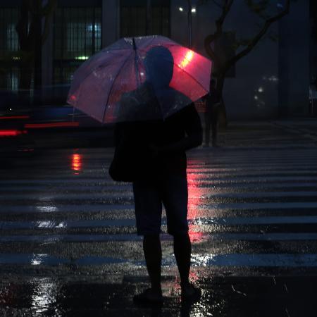 Pessoa usa guarda-chuva no centro da cidade de São Paulo Pessoa usa guarda-chuva no centro da cidade de São Paulo