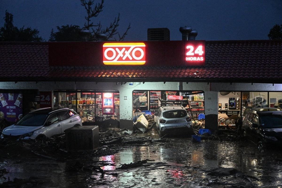 8.10.2026 - Veículos danificados são vistos em frente a uma loja de conveniência OXXO no bairro de Las Condes, em Santiago - undefined