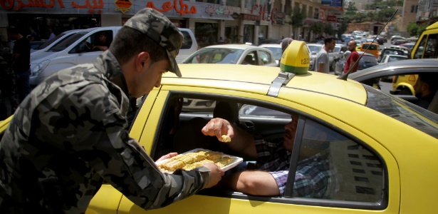 29.jul.2017 - Segurança palestino distribui doces para comemorar fim de restrições à entrada na Esplanada de Mesquitas, em Israel - Mamoun Wazwa/Xinhua