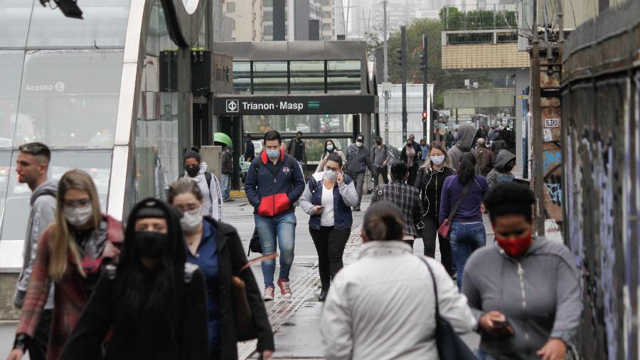Pedestres se protegem do clima frio e da garoa na Avenida Paulista, na região central de São Paulo - FÁBIO VIEIRA/ESTADÃO CONTEÚDO