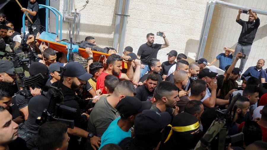 Durante o funeral, a polícia israelense tentou dispersar a multidão após a saída do hospital e o caixão quase caiu no chão - RANEEN SAWAFTA/REUTERS