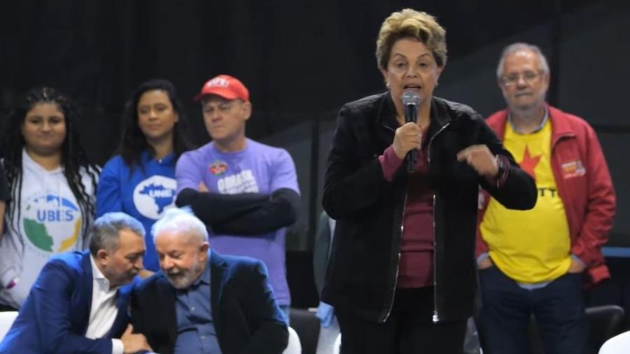16.set.2022 - A ex-presidente Dilma Rousseff (PT) discursa em Porto Alegre em ato de campanha do ex-presidente Lula (PT) ao Planalto; na imagem, o petista aparece conversando com o candidato do PT ao governo gaúcho, Edegar Pretto - Reprodução/YouTube/Lula