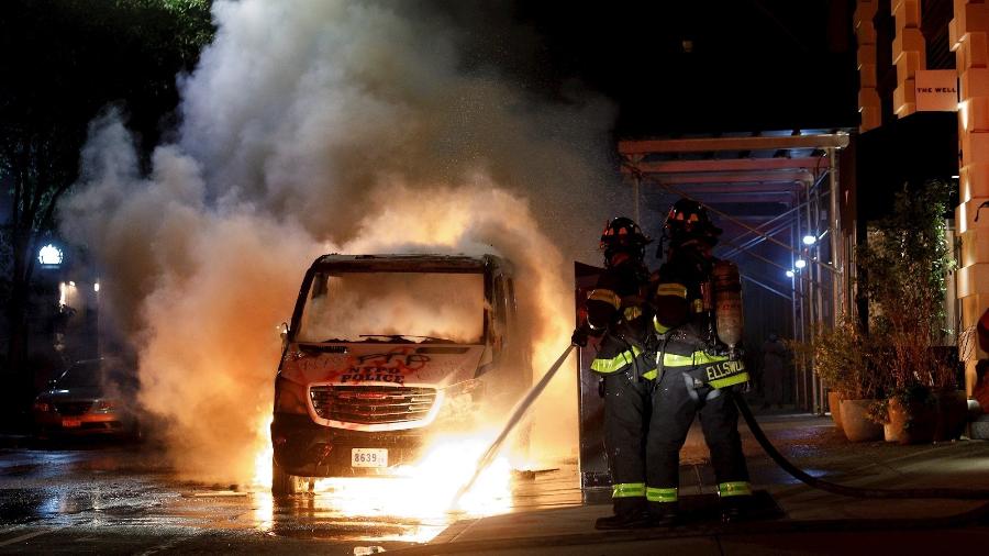 30.mai.2020 - Bombeiros apagam fogo em carro incendiado durante protestos pela morte de George Floyd em Nova York - Justin Lane/Efe
