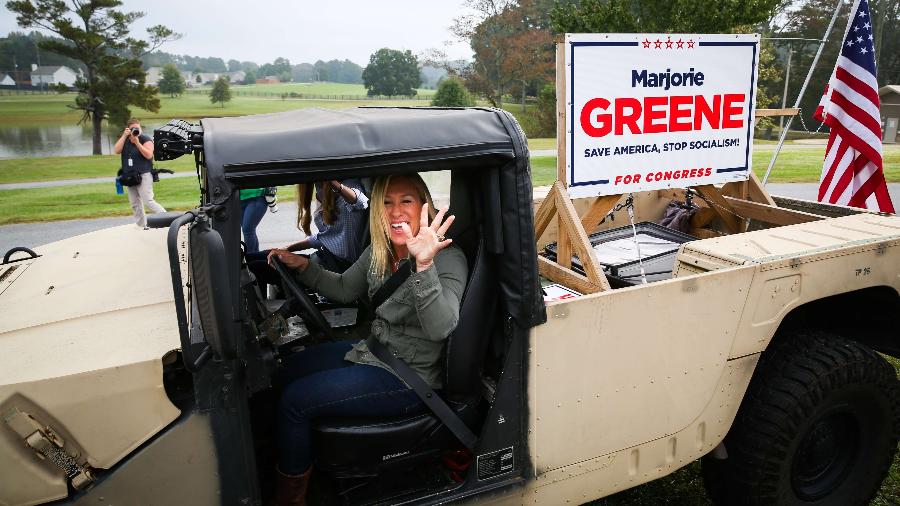 Marjorie Taylor Greene, eleita para o Congresso dos EUA, com cartaz de campanha: "Salve a América, pare o socialismo" - Dustin Chambers/Getty Images/AFP
