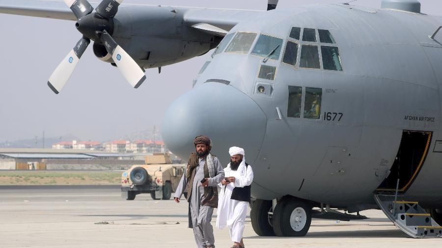31.ago.2021 - Talibãs caminham na frente de um avião militar um dia após a retirada das tropas dos EUA do Aeroporto Internacional Hamid Karzai em Cabul - Reuters/Stringer