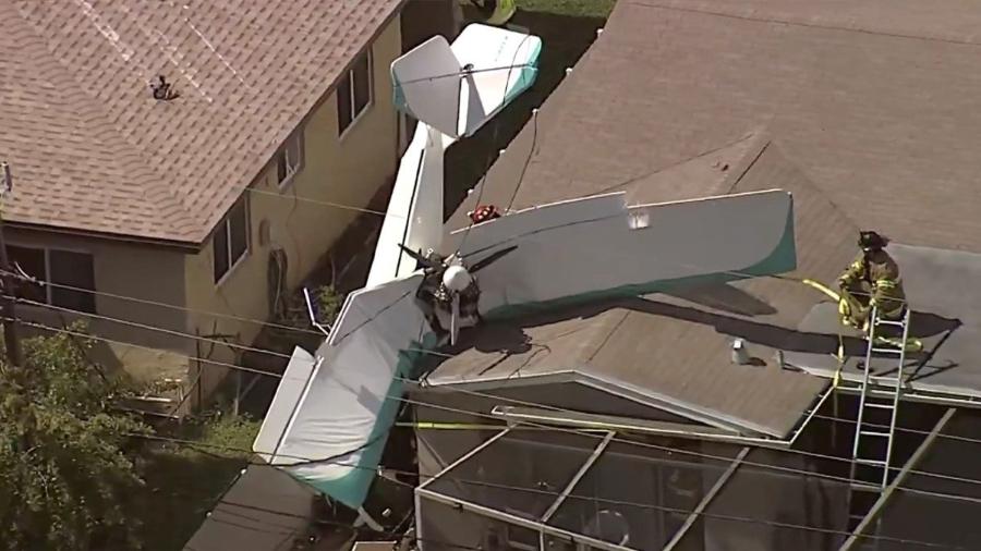 Imagens aéreas mostram o avião branco pendurado no telhado da casa - Reprodução/NBC