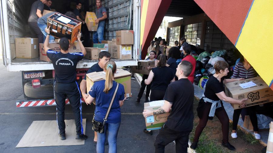Pessoas no 1º Grupamento de Bombeiros de Curitiba carregam caminhão com doações para vítimas da calamidade no Rio Grande do Sul - 9.mai.2024-Everson Bressan/Fotoarena/Estadão Conteúdo