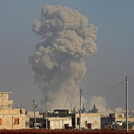 Arquivo - Fumaça é avistada após ataque aéreo na cidade de Saraqib, na Síria; em uma década, cerca de 400 mil pessoas morreram - Omar Haj Kadour/AFP