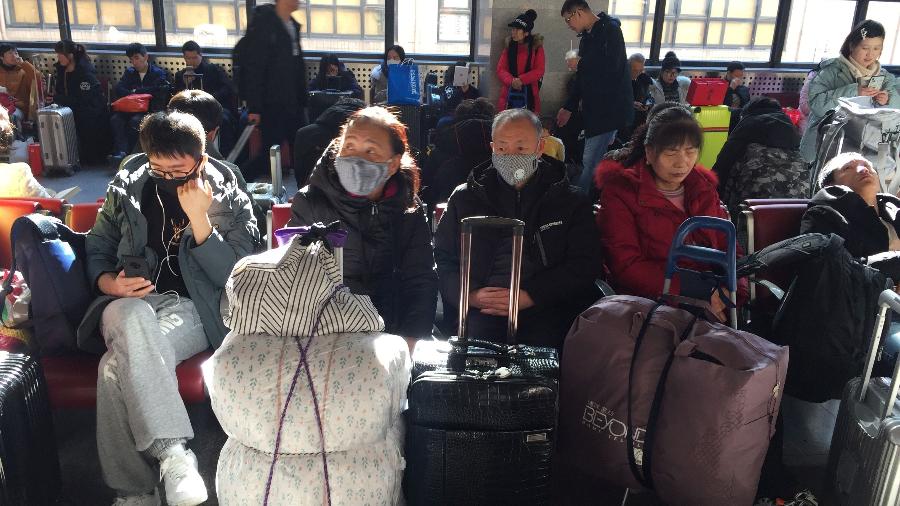 Passageiros usam máscaras para embarcar em trens na estação ferroviária oeste de Pequim - Stringer/Reuters