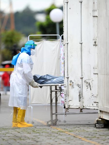 Um profissional de saúde, usando equipamento de proteção, transporta o corpo de vítima de coronavírus, no hospital Dr. João Lucio Pereira Machado, em Manaus - BRUNO KELLY/REUTERS
