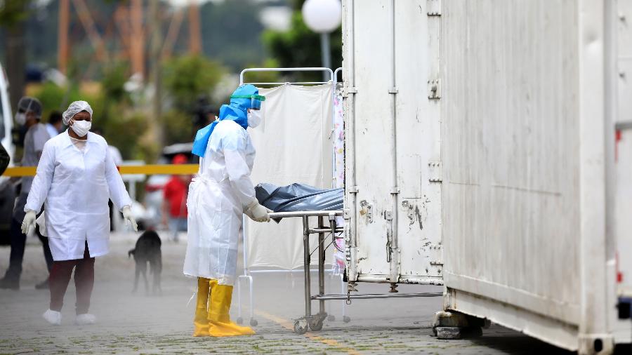 Uma profissional de saúde transporta o corpo de uma pessoa para um caminhão refrigerado durante o surto de doença por coronavírus em Manaus - BRUNO KELLY/REUTERS