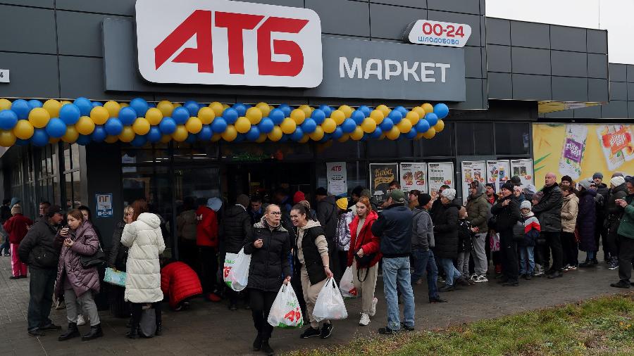 20.nov.22 - Pessoas esperam na fila para entrar em uma loja para fazer compras. Esse foi o primeiro supermercado ucraniano reaberto após o retiro militar russo de Kherson - REUTERS/Murad Sezer